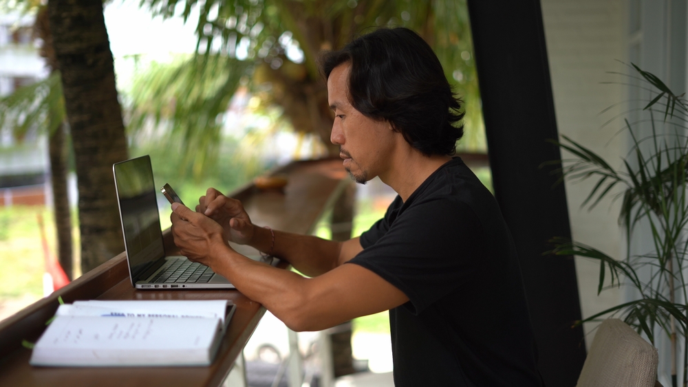 a man sitting at a desk using a laptop computer